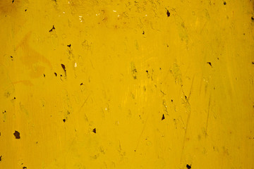 Rusty old metal surface painted in a dirty deep yellow color