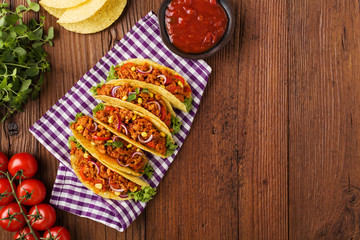 Tacos with meat and vegetables on wooden board