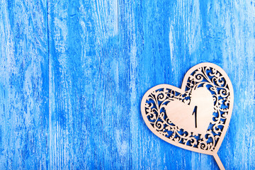 ooden heart carved on a blue wooden background