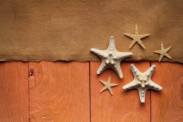 Fototapeta na wymiar Handmade paper sheet and starfish on wooden planks