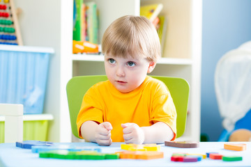 kid playing with building blocks at home or kindergarten