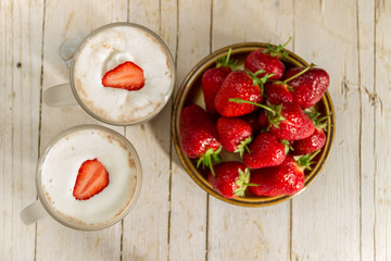 Какао со взбитыми сливками и клубникой на деревянном фоне. Здоровое питание