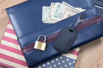 Safe travel, business and insurance concept / Secure USA travel: US dollar money, American flag, leather luggage label and security lock.