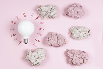 great idea concept with crumpled colorful paper and light bulb on light background. Creative brainstorm concept business idea.  female hand holding light bulb.