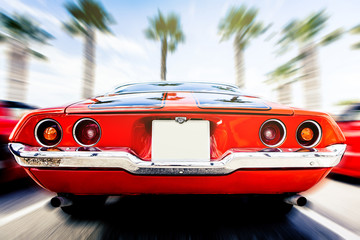 Back view of classic 1972 Chevrolet Camaro in orange color, in motion. Speeding. - obrazy, fototapety, plakaty
