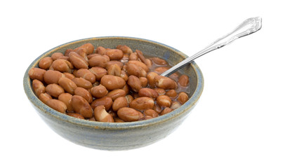 Bowl of shelled beans with a spoon isolated on a white background.