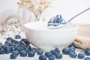 Juicy and fresh blueberries on the spoon with yogurt