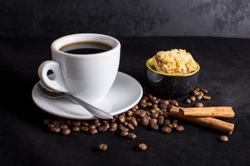 Obraz na płótnie Canvas Cup of black coffee with biscuits, cinnamon, dark backdrop