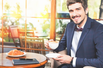 Handsome male has a french breakfast at cafe restaurant