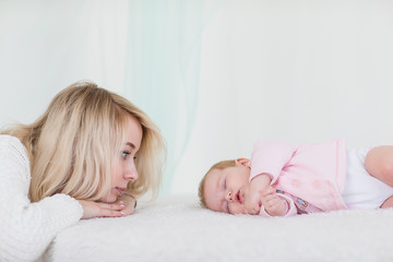 Fototapeta na wymiar mother puts her baby daughter to sleep