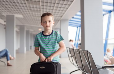 boy carrying his luggage at airport
