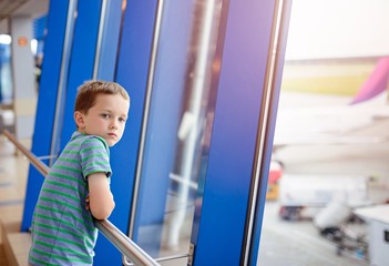 7 years old boy waiting for his plane at airport.