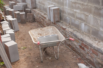 Old Construction cart on brick wall background.