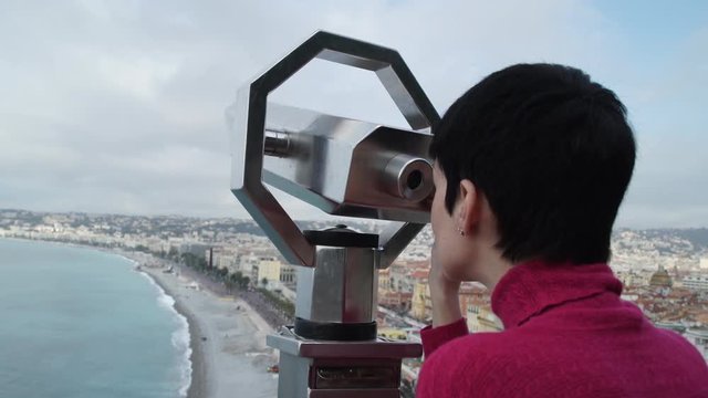 Happy female standing on the observation desk in Nice Cote d'Azur. Girl wearing in casual clothes red pullover and blue jeans. Sightseer at the holiday trip enjoy vacation. Caucasian model in