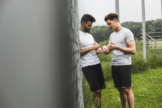 Two athletes witch smartwatches outdoors