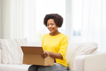 happy african young woman with parcel box at home