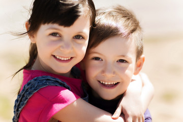 two happy kids hugging outdoors