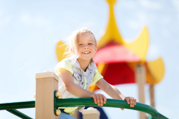 happy little girl climbing on children playground