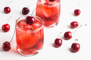 Red cocktail with cherry on the wooden background