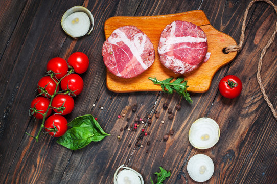 Ingredients for making homemade burger on wooden cutting board.