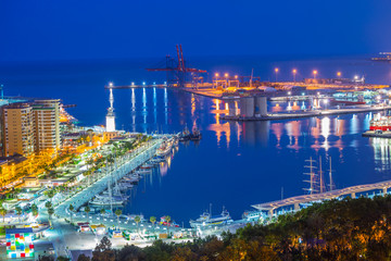 Beautiful aerial view over the sea port illuminated at night in Malaga - Andalusia, Spain