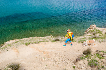 Fototapeta na wymiar Woman hiking walking with dog on seaside trail