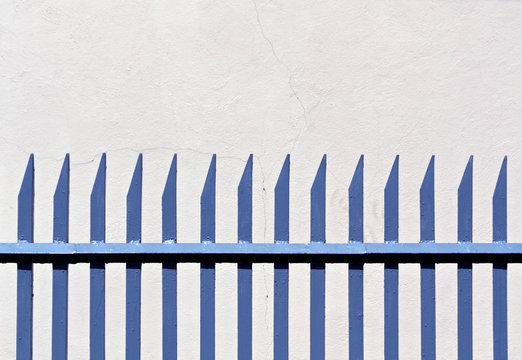 Blue Metal Fence And Plaster Wall.