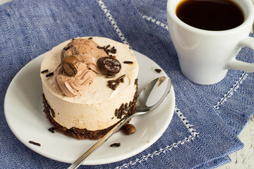  Cake and coffee.  Cake on a plate and a cup of coffee on blue napkin.