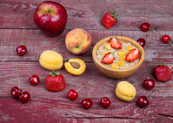 Oatmeal porridge with apricots, cherry, apple and strawberry on