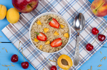 Oatmeal porridge with apricots and strawberry on table