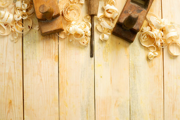 Carpenter tools on wood table background with sawdust. Copy space