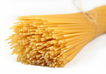 Bunch of uncooked Italian pasta spaghetti on a white