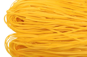 Uncooked Italian pasta tagliatelle on a white