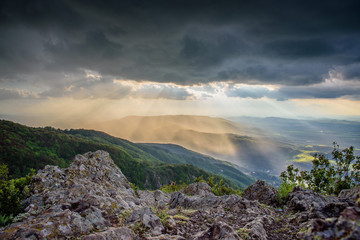Fototapeta na wymiar Sunset through thunderstorm clouds, hanging over Vitosha mountain in Sofia, Bulgaria
