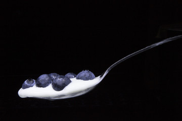 Blueberries in a spoon isolated on black background.Concept: Healthy living, fresh nutritions, fitness diet.