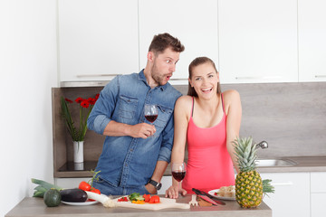 Young couple in kitchen with wine.