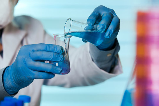scientist working in laboratory mixing liquids / chemist holding tubes test in the chemical lab