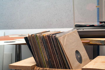 Retro styled image of a collection of old vinyl record lp's with sleeves on a wooden background