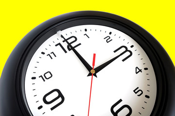 Fragment of big round wall clock, with a black rim isolated on white background close-up and arrows showing three o'clock isolated on yellow close-up