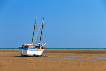 A beached sailing boat at low tide on the beach of Toliara, Madagascar