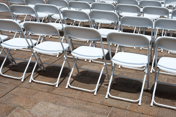 rows of folding chairs at event - 113917534
