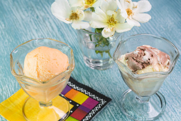 Orange sherbet and vanilla chocolate ice cream in a glass bowls.