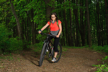 Fototapeta na wymiar Girl riding a bike in the woods