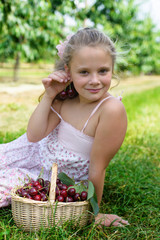 Portrait of a pretty girl with earrings of cherries in cherry garden