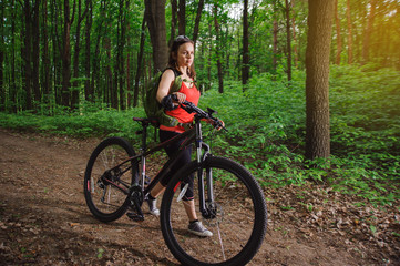 Fototapeta premium Girl riding a bike in the woods