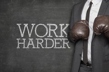 Work harder on blackboard with businessman on side