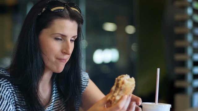 Young women eating fast food and drinkink milk cocktail