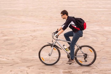 Bicyclist rides through the sands