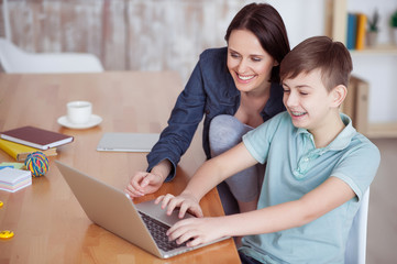 Fototapeta premium Happy mother helping his son to do homework
