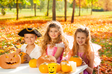 Children in costumes at Halloween craft pumpkin